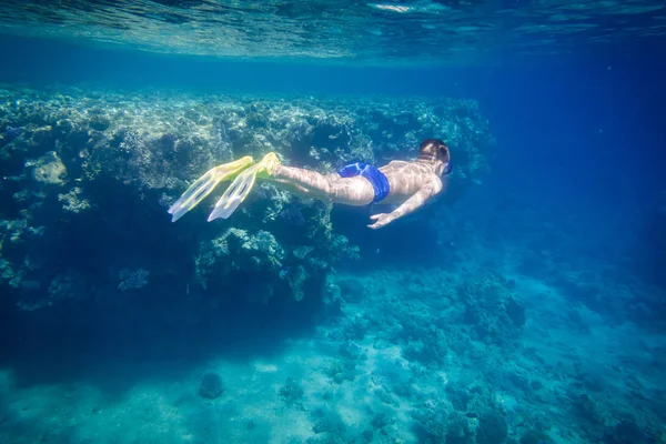 Boy buceo en el mar Rojo cerca de los arrecifes de coral — Foto de Stock