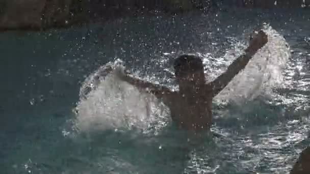 Silueta chlapce stříkající vodě v poool — Stock video