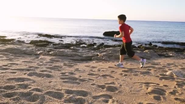 Αγόρι τρέχει στην παραλία στις ασκήσεις το πρωί — Αρχείο Βίντεο