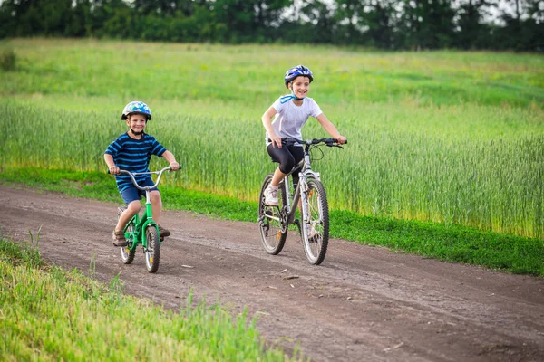 Två barn ridning på cyklar på lantlig väg — Stockfoto