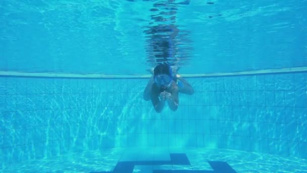Мальчик в маске ныряет в бассейн — стоковое видео
