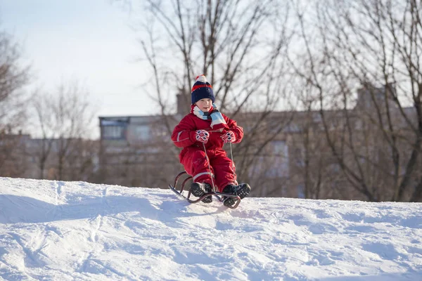 Happy boy at the sledge on top of snowy hill — ストック写真