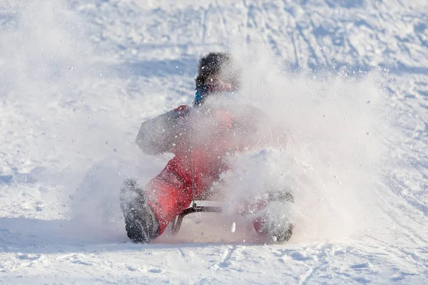 スライドで雪に覆われた丘の上に乗って幸せな少年 — ストック写真