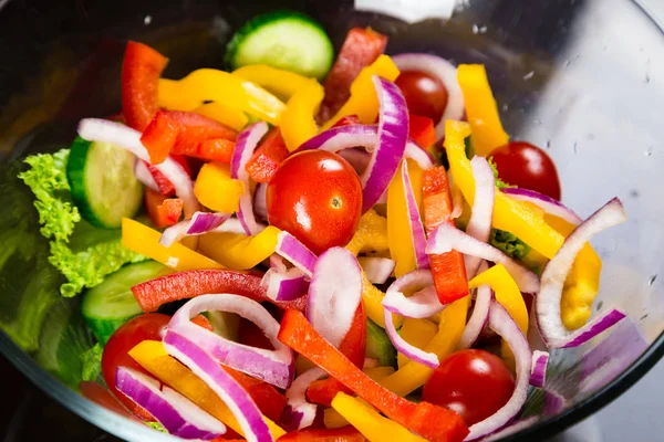 Крупный план приготовления нарезанных овощей к салату в стеклянной тарелке — стоковое фото