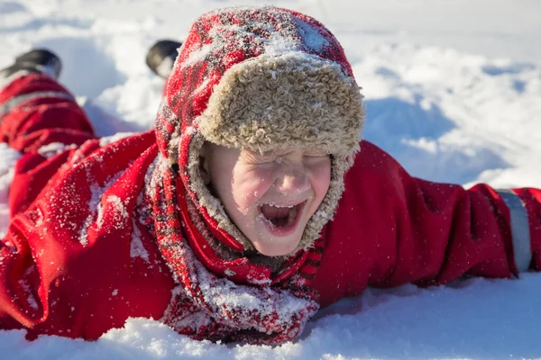 Adorable laughing boy at the snow background — Stock Photo, Image