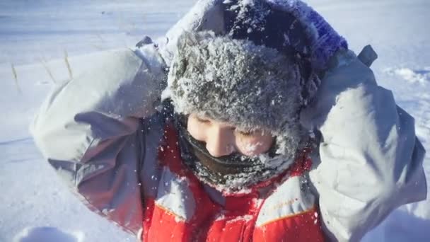Портрет счастливого мальчика на снегу в зимнем парке — стоковое видео