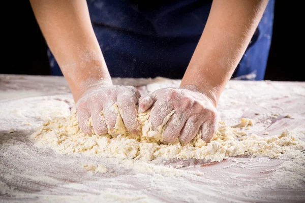 Womans hands kneading the dough on the table — Stock Photo, Image