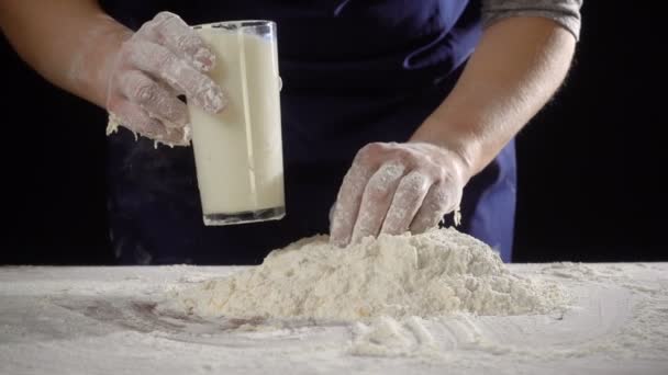 Womans hands pour the milk to dough for kneading — Stock Video