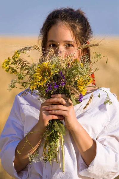 草场上的姑娘，手上拿着野花束 — 图库照片