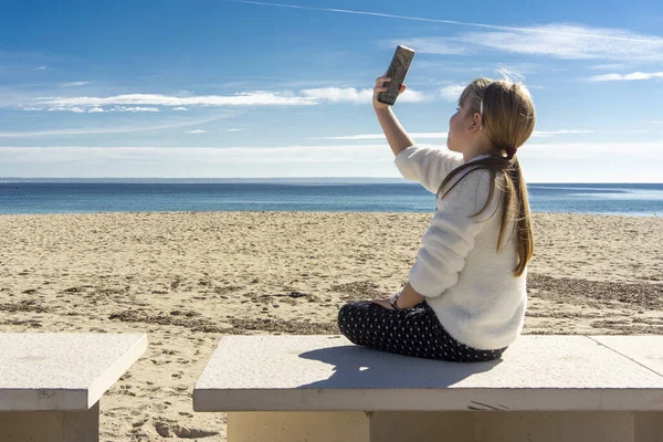 Giocare con il cellulare sulla spiaggia — Foto Stock