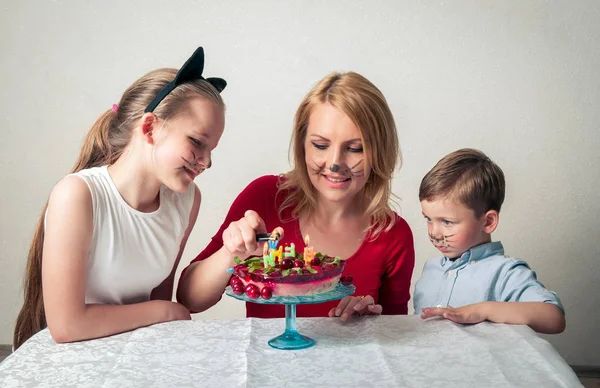 Niño con mamá y hermana con pastel de cumpleaños —  Fotos de Stock