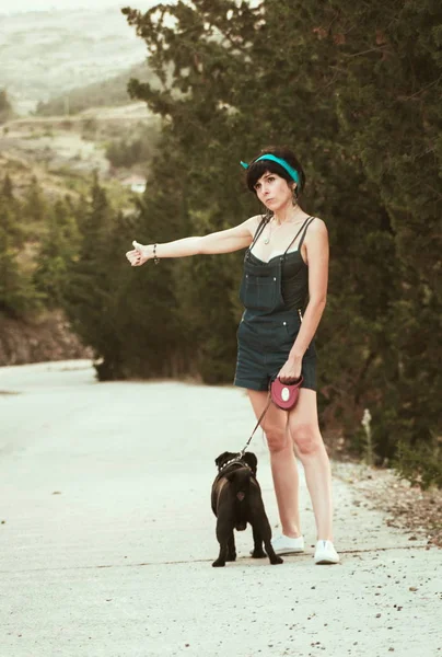 Tjej att ha kul med hennes mops hunden och stoppa bilar — Stockfoto