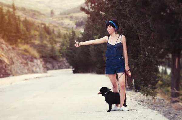 Mädchen hat Spaß mit ihrem Mops-Hund und stoppt Autos — Stockfoto