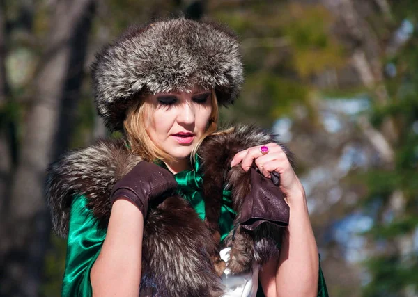 Beautiful blonde woman in winter clothes in the park — Stock Photo, Image