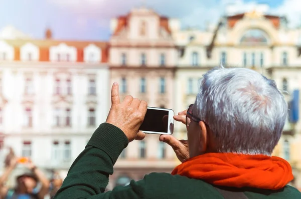 Старший турист фотографируется со смартфоном — стоковое фото