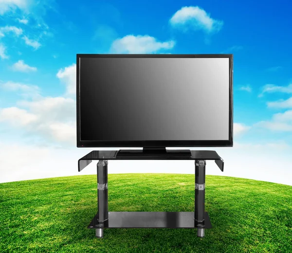 Телевизор на летней траве, усеянной небом — стоковое фото