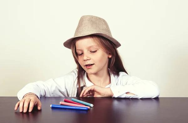 Menina bonita no chapéu com marcadores escolares — Fotografia de Stock