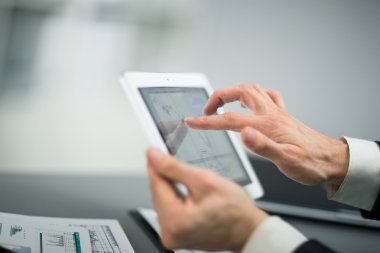 Dijital tabletin ekranına dokunan bir iş adamı