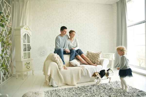 Família feliz com animal de estimação na sala de estar brilhante — Fotografia de Stock