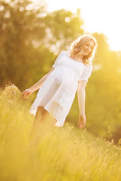 Happy těhotná žena chůze na slunečný den v parku — Stock fotografie