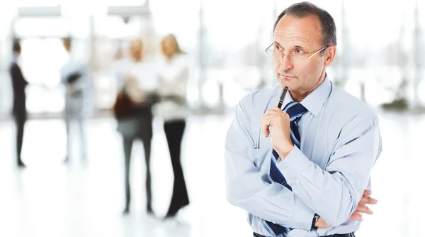 Portrait of a thinking businessman on background of office — Stock Photo, Image