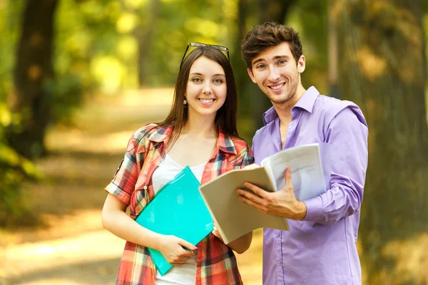 Couple of happy students with books in the Park on a Sunny day — Stockfoto