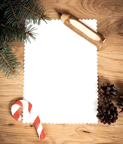 Blankt papper på trägolvet med en penna och julpynt — Stockfoto