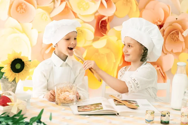 Lezzetli bir yemek hazırlamak için aşçı şeklinde mutlu küçük çocuklar. — Stok fotoğraf