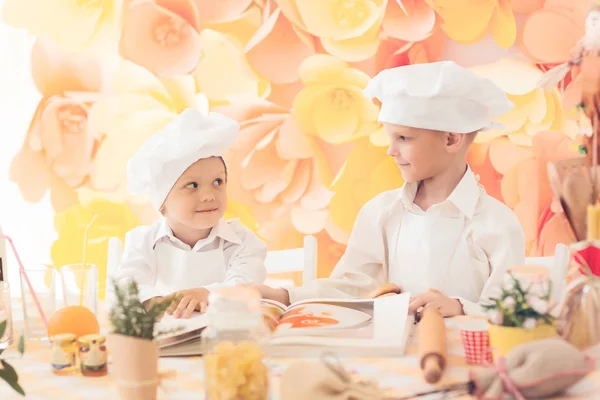 Счастливые маленькие дети в форме шеф-повара, чтобы приготовить вкусное — стоковое фото