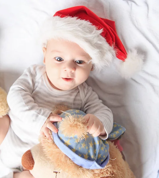 Cute baby in costume of Santa Claus with a toy. — Stock Photo, Image