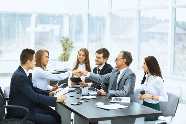 Reunião de negócios à mesa e aperto de mão de parceiros de negócios — Fotografia de Stock