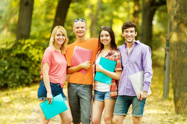 Grupp av glada studenter med böcker i parken på en solig dag. — Stockfoto