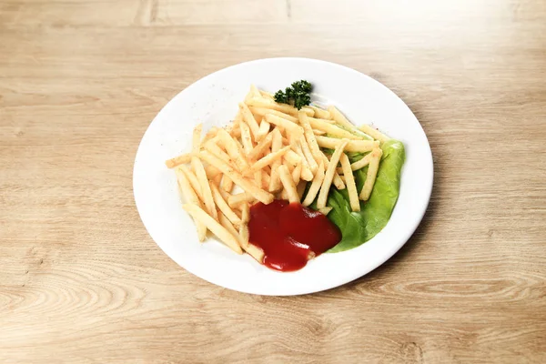 Картошка фри с соусом на белой тарелке на деревянном фоне — стоковое фото