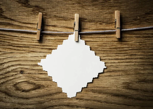 En blanco colgando de una cuerda, sobre fondo de madera —  Fotos de Stock