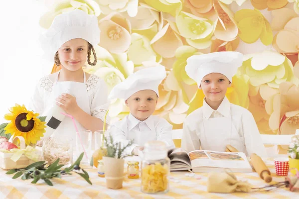 Lezzetli bir yemek hazırlamak için aşçı şeklinde mutlu küçük çocuklar. — Stok fotoğraf