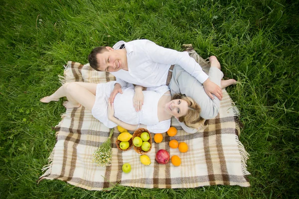 Pareja feliz - mujer embarazada y su marido en un picnic — Foto de Stock