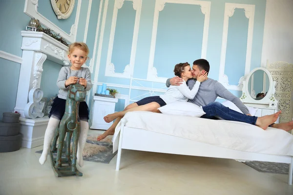 Menina montando em cavalo de madeira no quarto dos pais — Fotografia de Stock