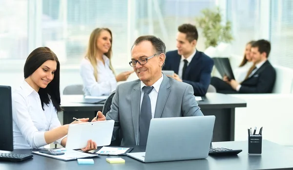 Succesvolle zakenman en zijn assistent bespreken het werkplan — Stockfoto