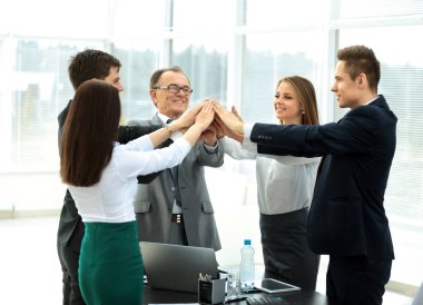 Mutlu iş adamları ofiste zaferi kutluyor.