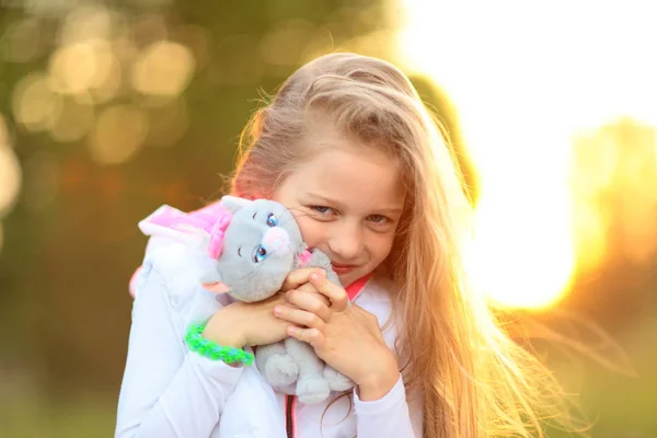 Красива маленька дівчинка з улюбленою м'якою іграшкою в парку — стокове фото