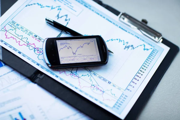 Business chart with smart phone and pen — Stock Photo, Image
