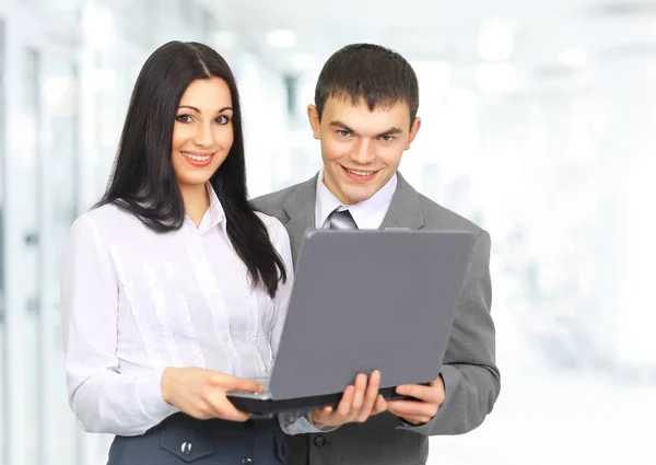 Vrouw receptioniste met een laptop en de client op de achtergrond — Stockfoto