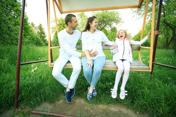 Těhotná žena s dcerou a manželem na procházce v parku — Stock fotografie