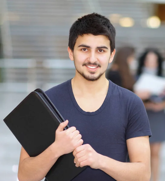 Joven negocio exitoso con una carpeta sonriendo y mirando la imagen —  Fotos de Stock