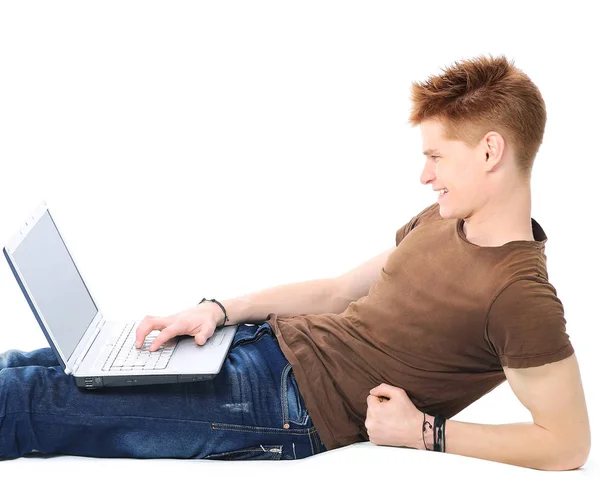 Exitoso hombre feliz acostado en el suelo usando una computadora portátil y mirando al monitor —  Fotos de Stock