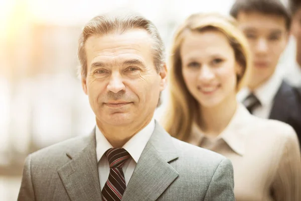 Hombre de negocios y exitoso equipo de negocios en la oficina mirando a la cámara sonriendo — Foto de Stock
