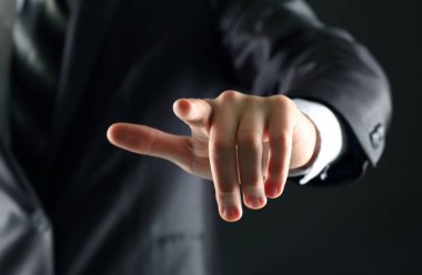 Sanal ekran siyah bir arka plan üzerinde hayali bir düğmeye basarak işadamı el