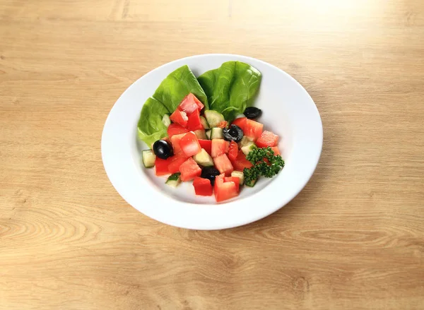 Ensalada de verduras sobre fondo de madera plato blanco — Foto de Stock