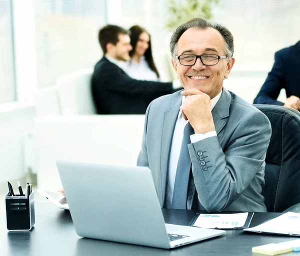 Erfolgreicher Geschäftsmann am Arbeitsplatz mit dem Laptop in einem modernen Büro — Stockfoto