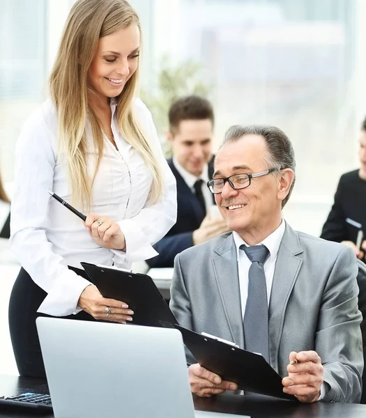 Erfolgreicher Geschäftsmann und seine Mitarbeiter diskutierten den Arbeitsplan vor dem Hintergrund eines funktionierenden Geschäftsteams — Stockfoto